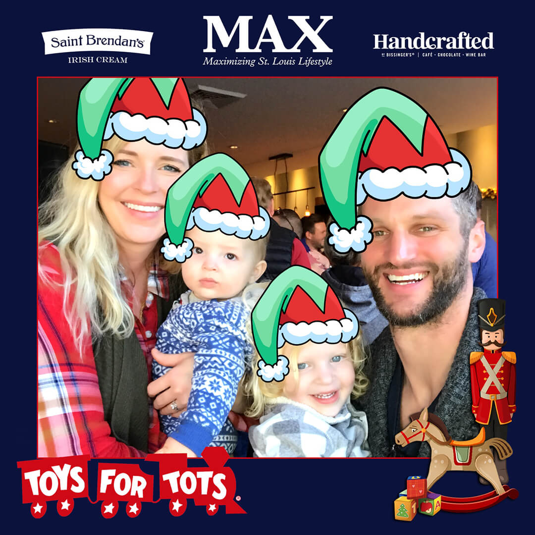 A family poses in a photo booth with holiday themed digital props applied at an event for Toys for Tots